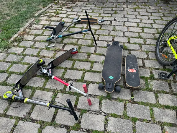 Drei Roller, ein Longboard und ein Skateboard